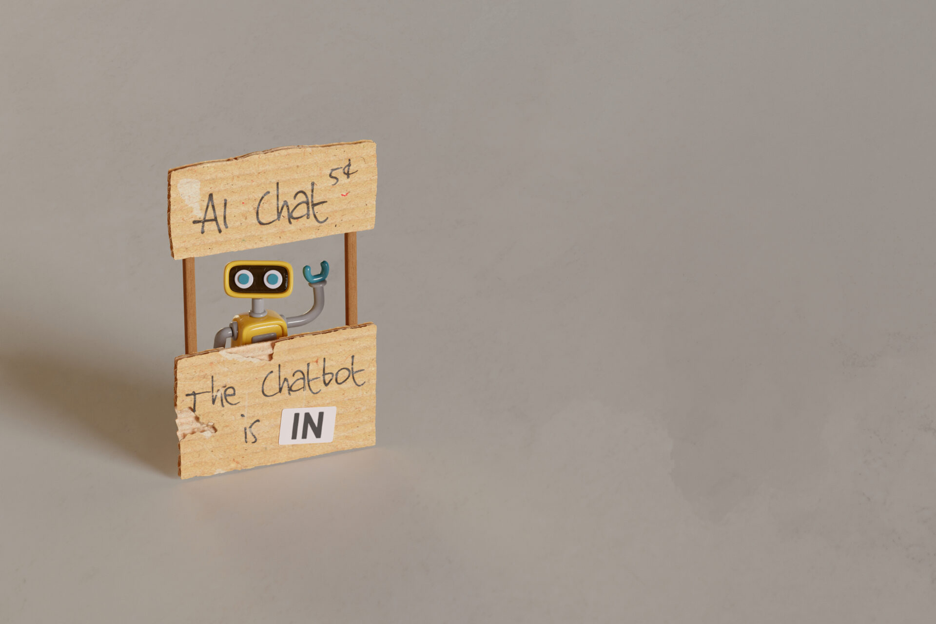 yellow-toy-robot-manning-ai-chat-stand-2023–04-21–21-37–23-utc